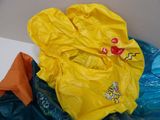 a yellow rain coat and a blue bag on a table
