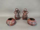three small vases with handles and handles sitting on a table