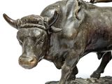 a statue of a man riding a bull on top of a book