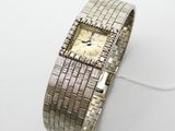 une photo d'une montre pour femme posée sur une surface blanche
