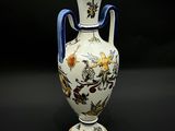 un vase avec une anse bleue sur fond noir