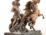 bronze statue of a man on a horse drawn carriage with two men on it