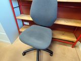 une chaise placée devant une bibliothèque