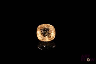 gros plan d'un diamant jaune sur une surface noire