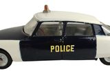 une petite voiture de police posée sur une surface blanche