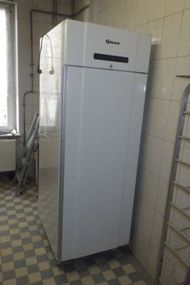 a white refrigerator in a kitchen with a checkered floor