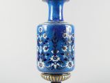 a blue vase with a gold rim on a white background