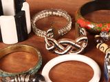 a lot of bracelets and rings on a table