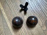 two balls sitting on a wooden floor next to each other