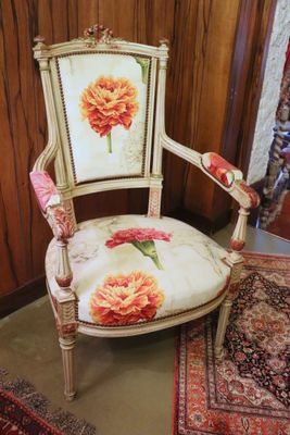 a chair that has a flower on the back of it