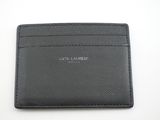 un porte-cartes en cuir noir posé sur une table blanche