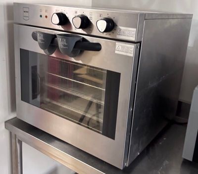 a stainless steel oven sitting on a table in a kitchen