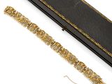 une photo représentant un bracelet en or et diamants ainsi qu'un écrin noir