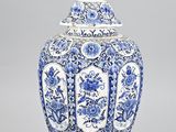 un vase bleu et blanc muni d'un couvercle et orné de fleurs
