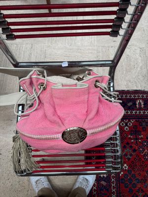 a pink purse sitting on top of a shopping cart