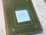 un livre vert sur lequel on voit des inscriptions, posé sur une table