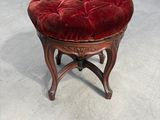 tabouret rembourré en velours rouge avec des pieds en bois