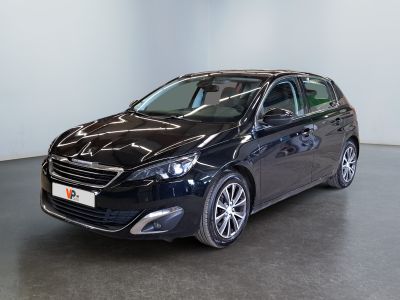 La voiture noire est garée dans une grande pièce au sol noir.