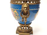 a blue and gold vase with a lion head on it