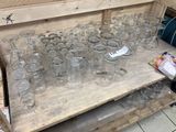 de nombreux verres vides posés sur une table en bois dans une pièce