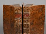 deux vieux livres posés l'un sur l'autre sur une table