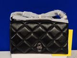 black and white quilted purse sitting on top of a white counter