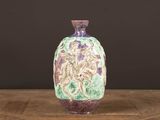un vase violet posé sur une table en bois, sur fond noir