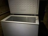 a white chest freezer sitting in a dark room