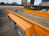 an orange flatbed trailer parked in a parking lot