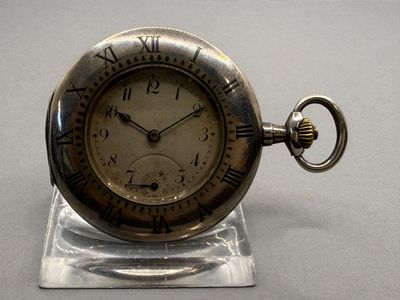 a silver pocket watch with roman numerals on it
