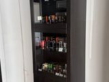 une grande armoire noire contenant de nombreuses bouteilles