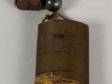 a small bell hanging from a string on a white surface