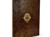 un vieux livre avec un emblème en or sur la couverture