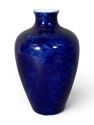 a blue vase that is sitting on a white surface