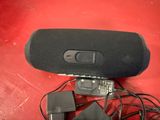 a black speaker that is sitting on a red surface
