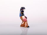 a figurine of a cat that is standing on a white surface