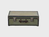 une vieille valise posée sur une surface blanche