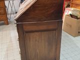 a small wooden cabinet in the middle of a room