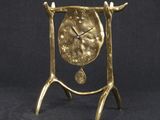 an image of a gold clock on a stand against a black background