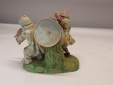 a figurine of two people playing with a drum