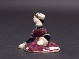 a figurine of a woman sitting on a rock