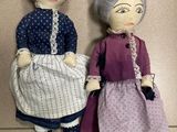 two dolls that are sitting next to each other on the floor