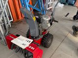 a man that is standing next to a small lawn mower