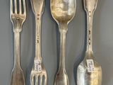 quatre cuillères en argent et une fourchette posées sur une table, accompagnées d'une étiquette de prix