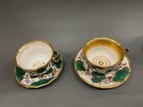 two cups and saucers are sitting on a table