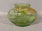 a green glass vase with a gold design on it