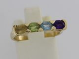 gros plan d'une bague en or avec trois pierres de couleurs différentes