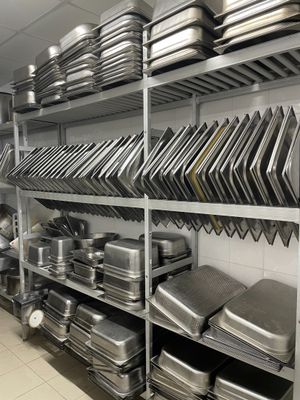 de nombreuses casseroles et poêles sur les étagères de la cuisine