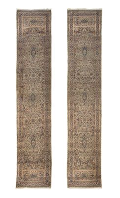 une paire de tapis persans anciens sur fond blanc