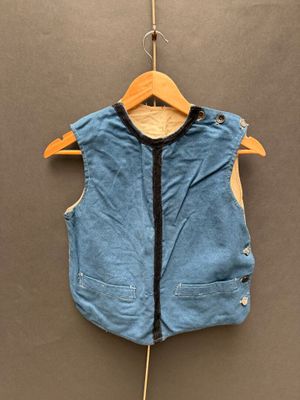 un gilet bleu accroché à un cintre sur un mur